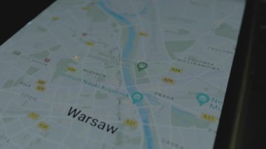 Akıllı telefon ekranında küresel haritada online uçuş takibi. Hareketli uçak. Varşova, Polonya. Kargo, kargo ve lojistik konsepti.
