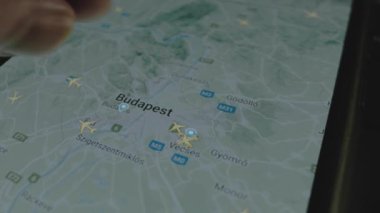 Akıllı telefon ekranında küresel haritada online uçuş takibi. Budapeşte, Macaristan. Kargo, kargo ve lojistik konsepti.