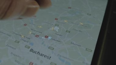 Akıllı telefon ekranında küresel haritada online uçuş takibi. Bükreş, Romanya. Kargo, kargo ve lojistik konsepti.