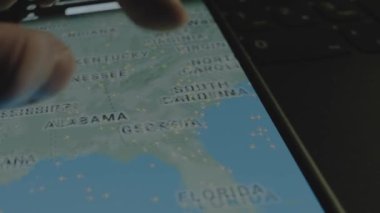 Akıllı telefon ekranında küresel haritada online uçuş takibi. Miami, New York, ABD. Kargo, kargo ve lojistik konsepti.