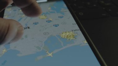 Akıllı telefon ekranında küresel haritada online uçuş takibi. J. F. Kennedy Uluslararası Havaalanı, New York, ABD. Kargo, kargo ve lojistik konsepti.