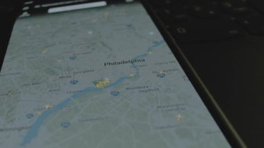 Akıllı telefon ekranında küresel haritada online uçuş takibi. Philadelphia, ABD. Kargo, kargo ve lojistik konsepti.