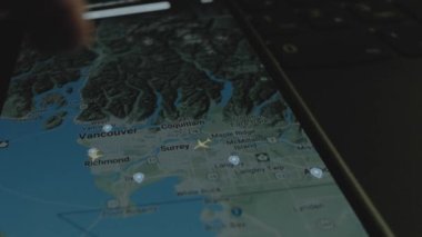 Akıllı telefon ekranında küresel haritada online uçuş takibi. Vancouver, Kanada. Kargo, kargo ve lojistik konsepti.