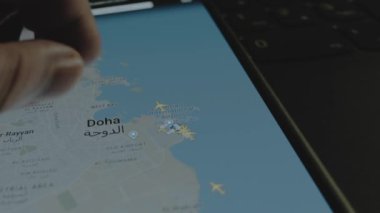 Akıllı telefon ekranında küresel haritada online uçuş takibi. Doha, Katar. Kargo, kargo ve lojistik konsepti.