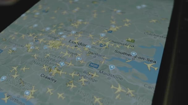 スマートフォン画面のグローバルマップ上のオンラインフライト追跡 ロンドン イギリス 船積み 物流コンセプト — ストック動画