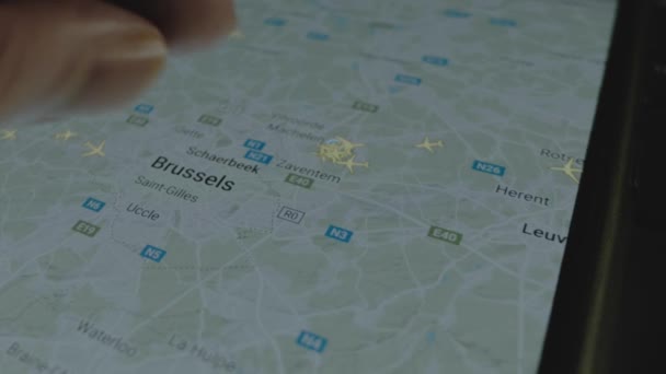 スマートフォン画面のグローバルマップ上のオンラインフライト追跡 ブリュッセル ベルギー 船積み 物流コンセプト — ストック動画