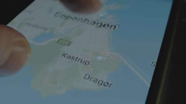 スマートフォン画面のグローバルマップ上のオンラインフライト追跡 コペンハーゲン デンマーク 船積み 物流コンセプト — ストック動画
