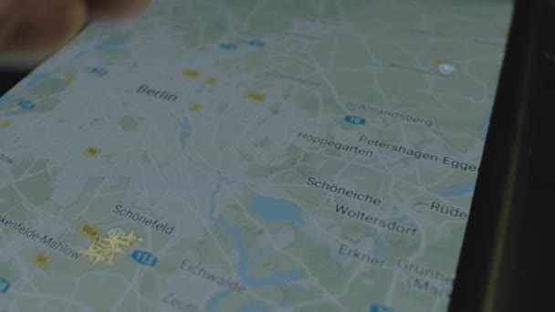 スマートフォン画面のグローバルマップ上のオンラインフライト追跡 ベルリン ドイツ 船積み 物流コンセプト — ストック動画