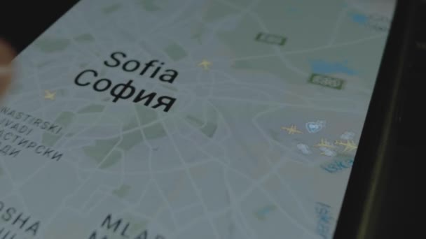 スマートフォン画面のグローバルマップ上のオンラインフライト追跡 ソフィア ブルガリア 船積み 物流コンセプト — ストック動画