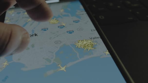 スマートフォン画面のグローバルマップ上のオンラインフライト追跡 ケネディ国際空港 ニューヨーク アメリカ合衆国 船積み 物流コンセプト — ストック動画
