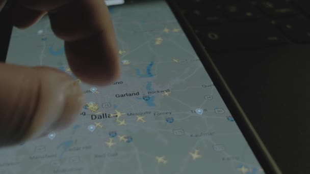 スマートフォン画面のグローバルマップ上のオンラインフライト追跡 ダラス アメリカ 船積み 物流コンセプト — ストック動画