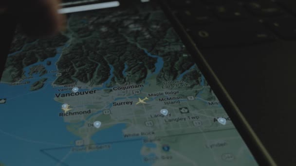 スマートフォン画面のグローバルマップ上のオンラインフライト追跡 バンクーバー カナダ 船積み 物流コンセプト — ストック動画