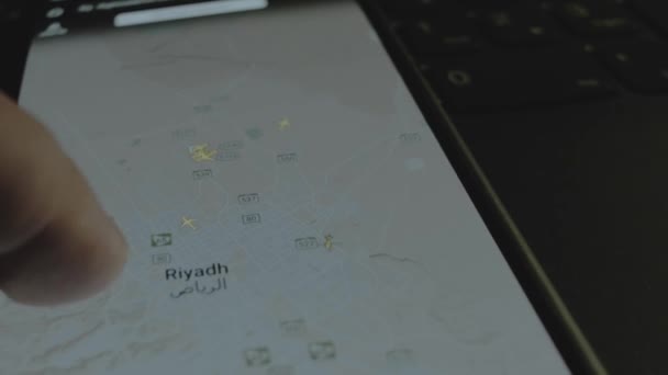 スマートフォン画面のグローバルマップ上のオンラインフライト追跡 リヤド サウジアラビア 船積み 物流コンセプト — ストック動画