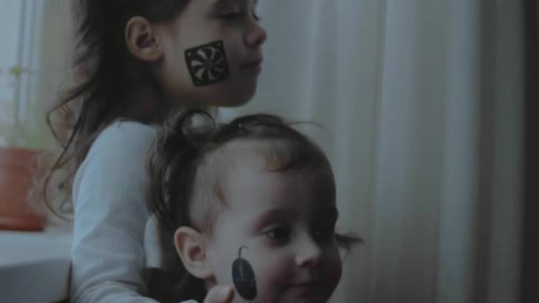 Две Маленькие Девочки Компьютерными Компонентами Рисуют Лицах Указывая Пальцем Картину — стоковое видео