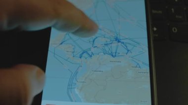 Dünya haritasındaki su altı internet kabloları akıllı telefon ekranında. Kuzey Atlantik Okyanusu.