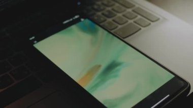 Cep telefonu ekranındaki suda çok renkli akrilik boyanın soyut arkaplanı. Işık çizgileri ekrandan gelir.