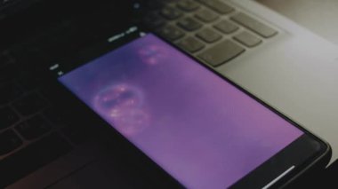 Akıllı telefon ekranında sabun köpükleri olan soyut mor arkaplan.