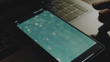 Akıllı telefon ekranında su yüzeyinde hava kabarcıkları patlıyor. Erkek el neşeyle kanat çırpıyor..