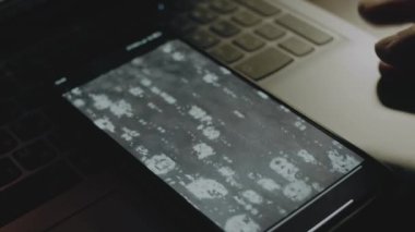 Cep telefonu ekranında su yüzeyindeki hava kabarcıkları patlıyor. Erkek el neşeyle kanat çırpıyor..