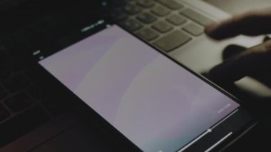 Akıllı telefon ekranındaki mor dalgaların soyut arkaplanı. Işık ışınları ekrandan geliyor. Erkek el neşeyle kanat çırpıyor..