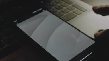 Akıllı telefon ekranındaki gri dalgaların soyut arkaplanı. Işık ışınları ekrandan geliyor. Erkek el neşeyle kanat çırpıyor..