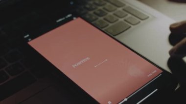 Pozitif titreşimler sadece akıllı telefon ekranındaki pembe arkaplanda yazılıdır. Işık ışınları ekrandan geliyor. Erkek el neşeyle kanat çırpıyor..