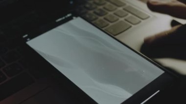 Akıllı telefon ekranındaki gri dalgaların soyut arkaplanı. Işık ışınları ekrandan geliyor. Erkek el neşeyle kanat çırpıyor..