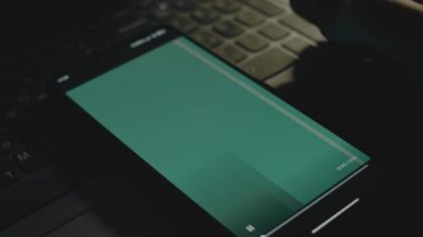 Akıllı telefon ekranında yapısal mühendislik yazıtları yeşil arka plan. İnşaat konsepti. Erkek el neşeyle kanat çırpıyor..