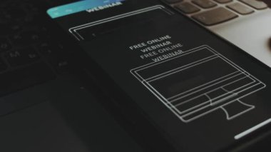 İnternet üzerinden ücretsiz webinar reklamcılığı. Akıllı telefon ekranında grafiksel tasarım. Erkek el neşeyle kanat çırpıyor..