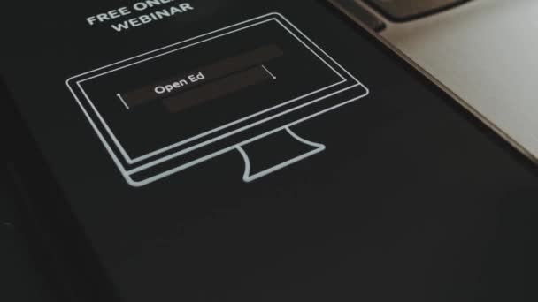 オープンな教育リソース 無料オンラインウェビナー スマートフォン画面のコンピュータモデルによる広告 指を元気に浮かべる男性の手 — ストック動画