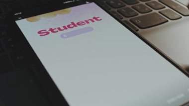 Öğrenci taahhüdü. Akıllı telefon ekranında grafiksel sunum. Beyaz arka planda suluboya fırça darbeleri. Erkek el neşeyle kanat çırpıyor..