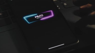 Akıllı telefon ekranında yazılı film endüstrisi. Neon çerçeve. Erkek el parmaklarıyla neşeyle çırpınıyor. Eğlence konsepti.