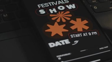 Müzik festivallerine adanmış bir gösteri tarihi. Akıllı telefon ekranında grafiksel sunum. Erkek el neşeyle parmaklarını çırpıyor. Eğlence konsepti.