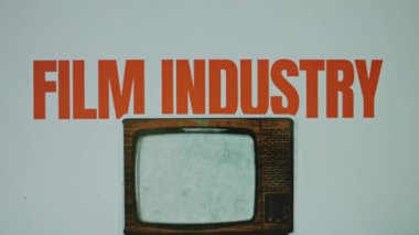 Gri arka planda film endüstrisi yazıları var. VHS efektli klasik televizyonun görüntüsüyle grafiksel sunum. Eğlence konsepti.