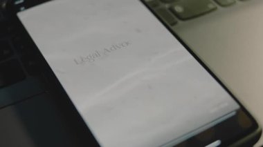Akıllı telefon ekranında yasal avukatlık yazıları var. Temiz su ve deniz kumu dalgalarıyla grafiksel sunum. Hukuki kavram.