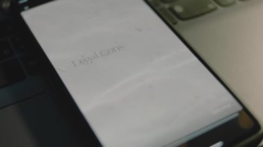 Akıllı telefon ekranında yasal danışmanlık yazıları var. Huzurlu su ve deniz kumu dalgalarını gösteren grafiksel bir sunum. Hukuki kavram.