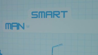 Mavi matematik tablosunda Akıllı İmalat yazıları. Resmedilmiş viteslerin grafiksel sunumu, ağırlık kaldırma vinci ve yel değirmeninin imalat sembolü olması. Üretim kavramı.