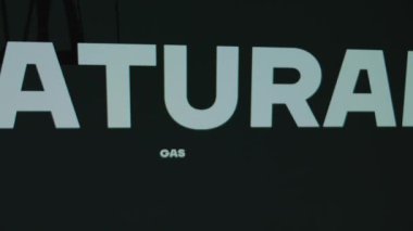 Siyah arkaplanda Doğal Gaz Üretim Yazısı. Petrol platformu sembolü ve şarj pili ile grafiksel sunum. Petrol ve gaz kavramı.