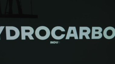 Hidrokarbon Endüstrisi kara arka planda yazılı. Deniz aşırı petrol platformunun sembolü ve şarj pili ile grafiksel sunum. Petrol ve gaz kavramı.