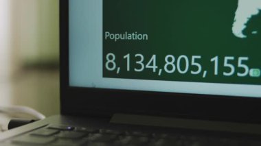 Laptop ekranında nüfus artışı var. Dünya nüfusunun etkileşimli sayımı. Görüntü dağıt ve salla.