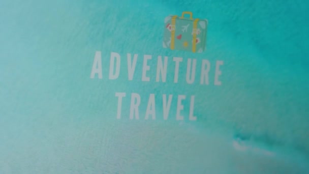 冒险旅行在蓝色海水背景上的题词 一个手提箱的说明 旅行概念 — 图库视频影像