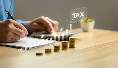 Yıllık vergilerini ve vergilerini hesaplayan bir iş adamı. Vergi indirimi konsepti. Giderler, hesaplar, KDV, gelir vergisi, vergi hesapları, harcamalar, muafiyetler, indirimler, bağışlar