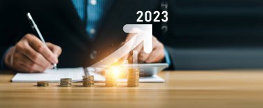 Business Strategy 2023, and Financial Business. Businessman calculates income and investment profit with positive growth indicators, arrow graph corporate future growth, trend, long term fund