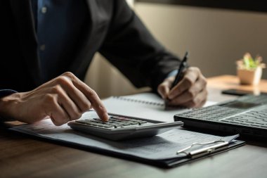 Ofis işleri ile ilgili iş ve finansal kavramlar. Analistler iş görüşmelerini hesap makinesiyle yapıyorlar. İş, mal, hizmet üretmeyi içerirken, finans para, yatırım ve riskleri yönetir