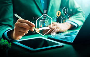 Bir tablet ve dizüstü bilgisayar üzerinde strateji, büyüme ve çevrimiçi kampanya yönetimi için analitik, reklam verileri ve sanal simgelerle dijital pazarlama arayüzü kullanan bir işadamı.