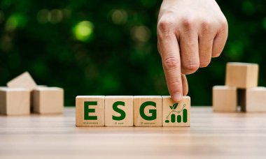 Çevresel, sosyal, yönetim ilkelerini temsil eden, sürdürülebilir iş büyümesini, kurumsal sorumluluğu, etik yatırımı vurgulayan ESG harfleriyle ahşap blokların elle düzenlenmesi.
