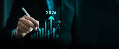 Sanal tablo çizmek için dijital kalem kullanan bir işadamıyla 2026 yılı stratejik iş büyümesi ve finansal planlama kavramı. Yatırım stratejisi, pazar eğilimi, hedef belirleme, veri analizi yeniliği
