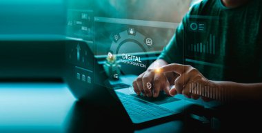 Bir dizüstü bilgisayarda, kullanıcının holografik gösterge paneline, yapay zeka simgelerine, grafiklere dokunduğu dijital dönüşüm arayüzü ve yenilik ve akıllı iş teknolojisini temsil eden parlayan mavi veri panelleri