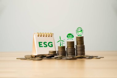 ESG investment concept with stacked coins and environmental icons representing renewable energy, carbon footprint reduction, and sustainable responsibility for long-term financial growth strategy