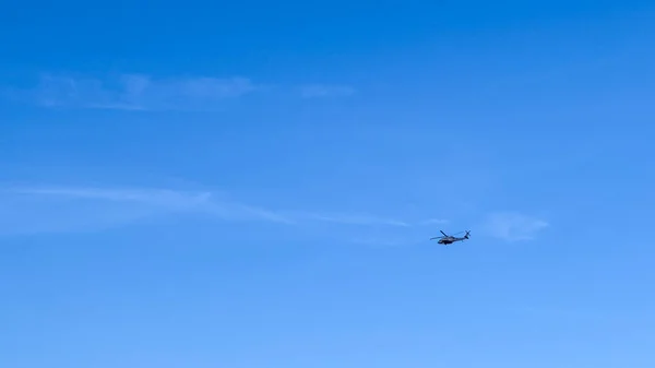 Mavi gökyüzünde uçan helikopter.